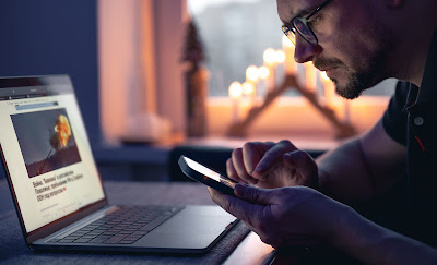 man-with-smartphone-sits-front-laptop-late-night_compressed.jpg